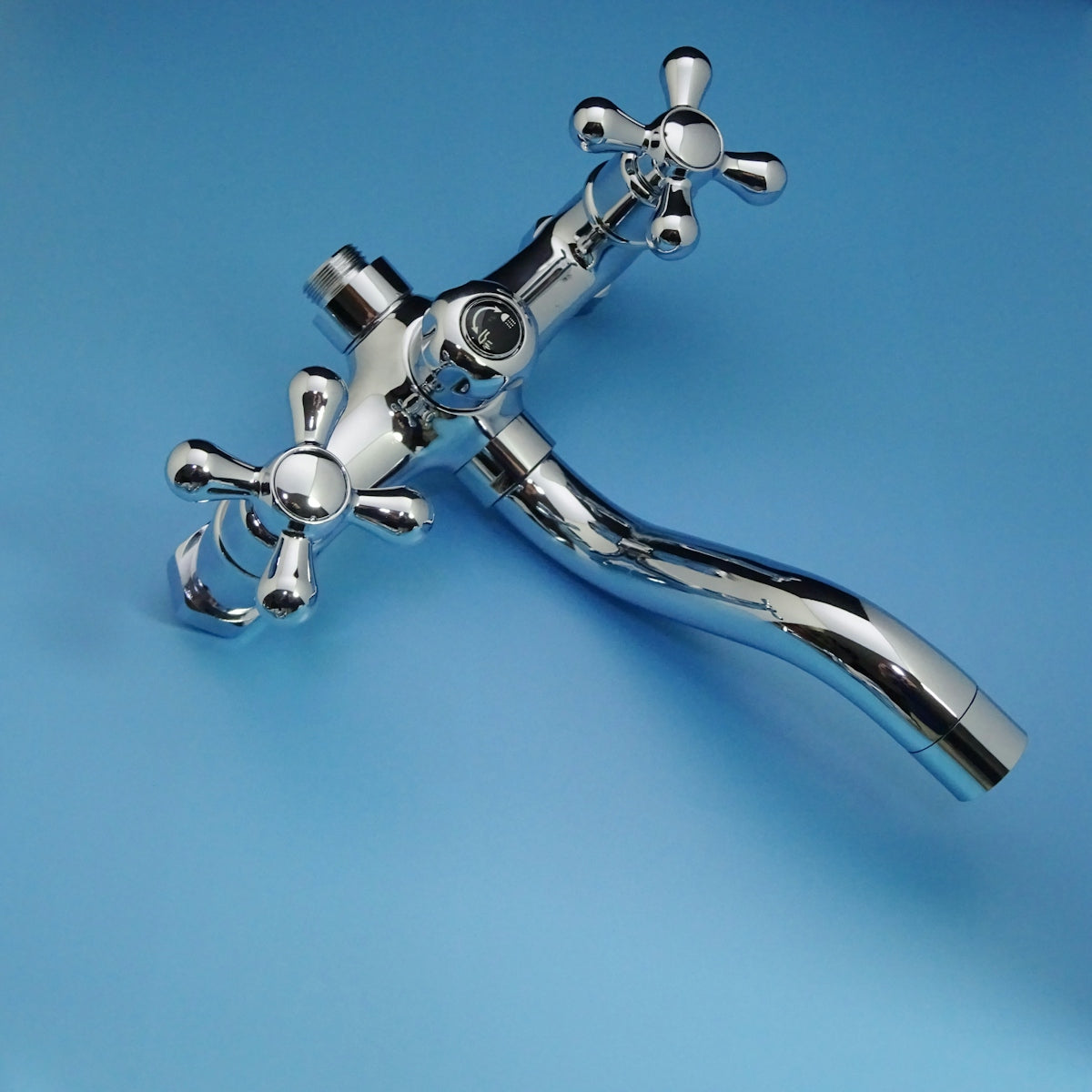 Chrome faucet with cross handles on blue background