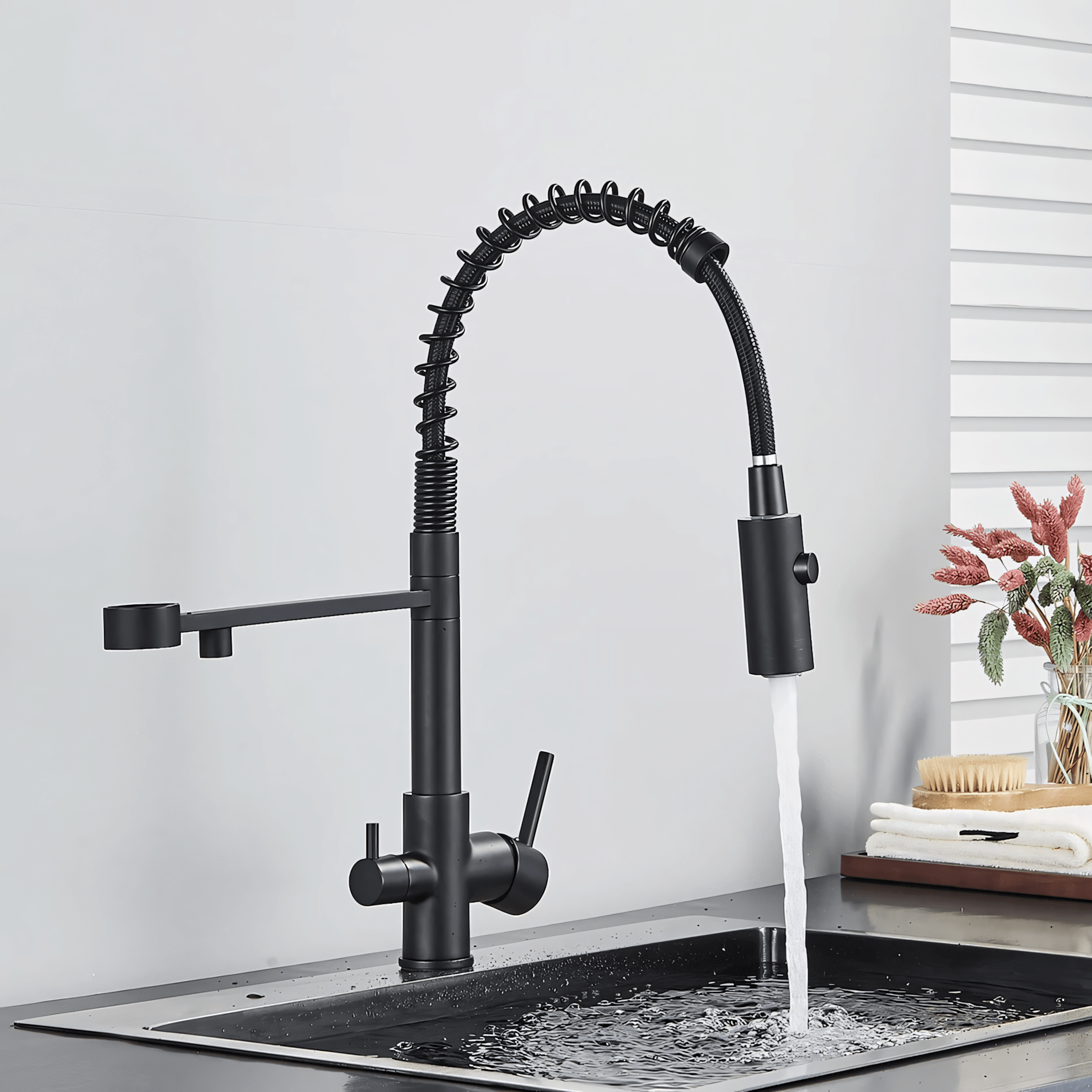 Black kitchen faucet with water flowing into a sink against a neutral background