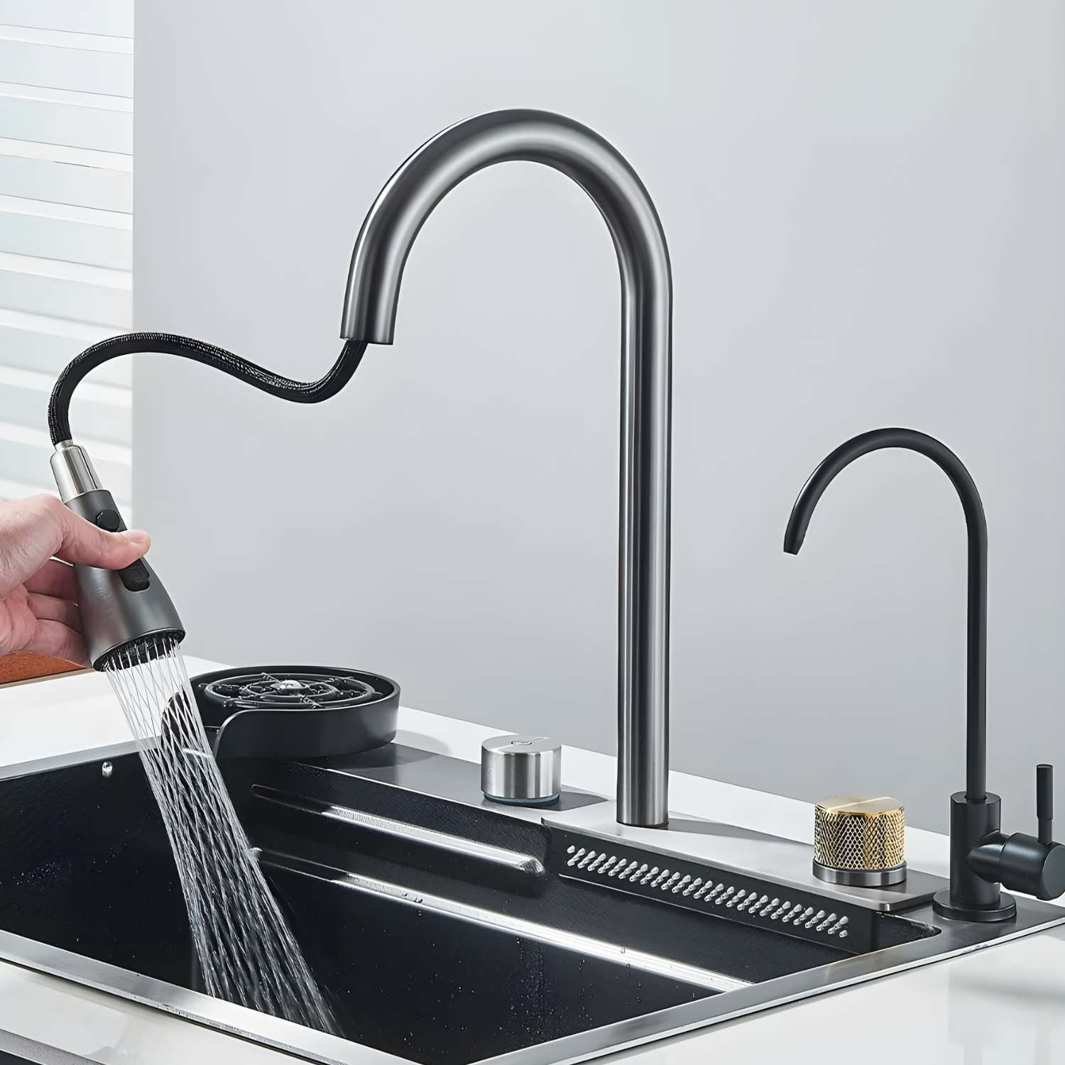 Black kitchen faucet with a handheld showerhead being used to wash dishes.